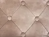 A close-up view of a tufted fabric surface with diamond-shaped stitching and circular buttons. Náhled obrázku produktu