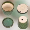 A collage of four views of a green ceramic plant pot with a fish scale pattern, showing the top, bottom, and side views, along with a matching saucer. Náhled obrázku produktu