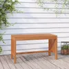 A wooden garden bench sits on a wooden deck in front of a white wooden wall with vines growing on it. Náhľad obrázku produktu