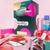 A Sephora advent calendar and various beauty products are arranged on a pink surface. Produktbild-Vorschau