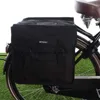 A black bicycle pannier bag attached to the rear rack of a bicycle. Náhled obrázku produktu