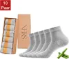 A collection of socks packaged in a box, with loose socks and bamboo stalks. Produktbild-Vorschau