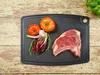A raw steak and vegetables are arranged on a cutting board. Anteprima dell’immagine prodotto