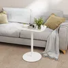 A white side table with a book, a cup of coffee, and a small plant is placed next to a light gray sofa with yellow and gray pillows and a gray blanket. Anteprima dell’immagine prodotto