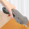 A hand holding a cordless electric scissors over a piece of orange material. Náhled obrázku produktu