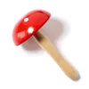 A wooden mushroom toy with a red cap and a white dot, on a white background. Produktbild-Vorschau