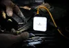 A person wearing gloves is handling ammunition next to a tactical power bank with a yellow cable. Produktbild-Vorschau