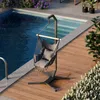 A hanging chair with cushions is placed on a wooden deck next to a swimming pool. Produktbild-Vorschau