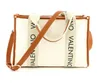 A white Valentino tote bag with brown leather trim and straps, featuring the brand name printed on the straps. Anteprima dell’immagine prodotto