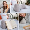 A collage of images showing a woman reading with a reading pillow, close-ups of the reading pillow, and a book resting on the pillow. Produktbild-Vorschau