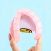 Pinker flexibler Slipper mit gelbem Smiley-Design, von Fingern gehalten vor hellblauem Hintergrund Náhled obrázku produktu