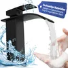 A black waterfall faucet is shown with water flowing into soapy hands. There is also a blue tag with text on it. Produktbild-Vorschau
