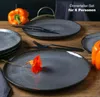 A set of dinner plates with cutlery and orange peppers on a wooden table. Produktbild-Vorschau