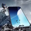 A mountain biker is shown jumping off a rocky ledge with a large smartphone screen superimposed in the foreground, showing a blue sky with abstract waves and debris falling. Podgląd zdjęcia produktu