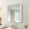 A white bathroom cabinet with mirrored doors is mounted on a tiled wall above a sink and faucet. Náhled obrázku produktu