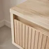 A close-up view of a wooden nightstand with a slatted drawer front. Produktbild-Vorschau