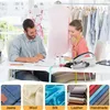 A man and a woman are working at a sewing table with fabric and a sewing machine. Below are fabric swatches. Produktbild-Vorschau