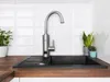 A kitchen sink with a faucet and two potted plants. Anteprima dell’immagine prodotto