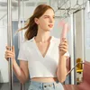 A woman holding a pink fan on a public transport. Anteprima dell’immagine prodotto