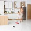 A woman is cleaning a modern kitchen floor with a mop. Produktbild-Vorschau