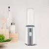 A white and silver mini blender with a clear bottle sits on a white surface, with kitchen items like a wooden spoon, a salt shaker, and a bottle of oil in the background. Produktbild-Vorschau
