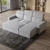A light gray sectional sofa is shown in a living room setting with a dark gray rug and wooden flooring. Produktbild-Vorschau