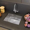 A modern kitchen sink with a faucet, a jar of nuts, and a bowl of figs. Produktbild-Vorschau
