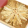 A straw star ornament is displayed in a cardboard box. Produktbild-Vorschau