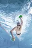 Underwater shot of a man swimming in a pool with swim paddles. Produktbild-Vorschau