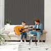 A father and son are sitting on a couch, with the son playing the guitar and the father looking at a book. Produktbild-Vorschau