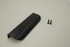 A black cabinet handle and two screws are laid out on a light gray surface. Produktbild-Vorschau