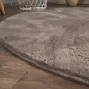 A close-up view of a round, shaggy rug on a wooden floor. Anteprima dell’immagine prodotto