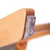 Close-up of a wooden chair leg with a clear plastic protective cap attached with screws. Náhled obrázku produktu