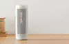 A white dehumidifier stands on a wooden table next to a jar of beans. Voir les images du produit