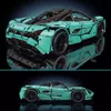 A collage of two images showing a teal-colored toy sports car model from different angles, displayed on a reflective black surface against a dark background. Produktbild-Vorschau