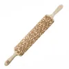 A wooden rolling pin with an engraved floral and berry pattern. Produktbild-Vorschau