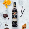 A bottle of Brugal Extra Viejo rum surrounded by ingredients like oranges, chocolate, coffee beans, vanilla pods, and caramel. Produktbild-Vorschau