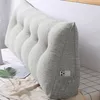 A grey wedge pillow with a side pocket is placed on a bed. Produktbild-Vorschau