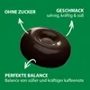 A single dark brown candy is shown against a green background, with text overlays highlighting its features. Produktbild-Vorschau