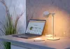 A desk setup with a laptop, a desk lamp, and a plant. Produktbild-Vorschau
