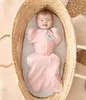 A baby is swaddled in a pink swaddle in a woven bassinet. Anteprima dell’immagine prodotto