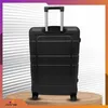 A black suitcase with a retractable handle is shown from the back, standing on a wooden surface against a striped background. Anteprima dell’immagine prodotto