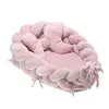 A pink baby nest with a braided bumper and a crescent moon pillow, isolated on a white background. Náhled obrázku produktu