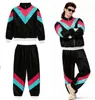 A man wearing an 80s/90s style tracksuit, with a separate tracksuit laid out. Voir les images du produit