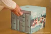 A person's hands are opening a Christmas advent calendar with a winter village scene on the side. Anteprima dell’immagine prodotto