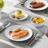 A table setting with multiple plates of food, including steak, salmon, dessert, and fruit salad, suggesting a formal dining experience. Produktbild-Vorschau