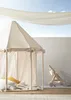 A children's play tent set up outdoors with a toy stroller nearby. Produktbild-Vorschau