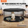 A dog is inside a black hexagonal pet playpen with a black cover, in a room with wooden floors. A person is sitting on a couch in the background. Produktbild-Vorschau