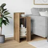 A wooden side table with books and a cup of coffee next to a gray sofa and a plant. Podgląd zdjęcia produktu