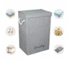 A gray laundry basket with a lid and rope handles, surrounded by small circular images of folded clothes, slippers, a teddy bear, and folded towels. Podgląd zdjęcia produktu